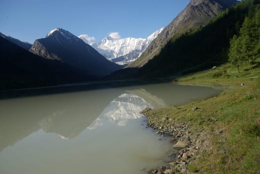 The mountain river in the mountains. Current through the gorge the river. Stones and rocky land near the river. Beautiful mountain landscape.