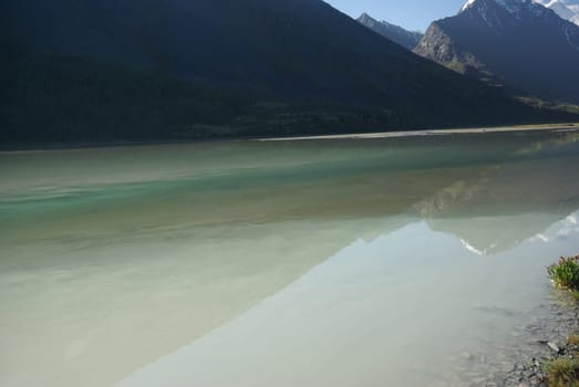 The mountain river in the mountains. Current through the gorge the river. Stones and rocky land near the river. Beautiful mountain landscape.