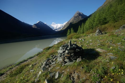 The mountain river in the mountains. Current through the gorge the river. Stones and rocky land near the river. Beautiful mountain landscape.