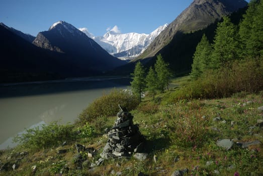 The mountain river in the mountains. Current through the gorge the river. Stones and rocky land near the river. Beautiful mountain landscape.
