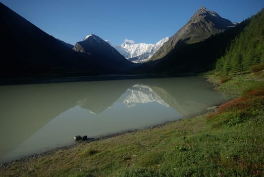 The mountain river in the mountains. Current through the gorge the river. Stones and rocky land near the river. Beautiful mountain landscape.