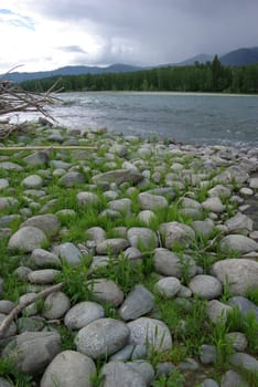 The mountain river in the mountains. Current through the gorge the river. Stones and rocky land near the river. Beautiful mountain landscape.