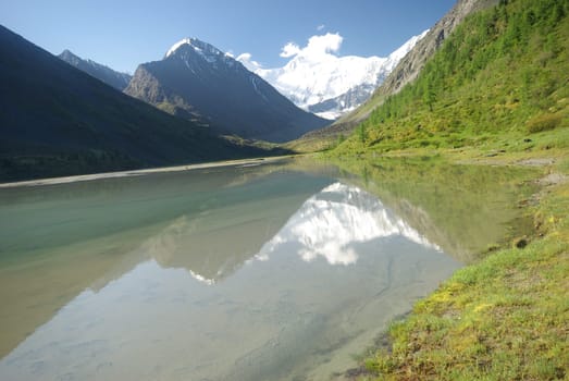 The mountain river in the mountains. Current through the gorge the river. Stones and rocky land near the river. Beautiful mountain landscape.
