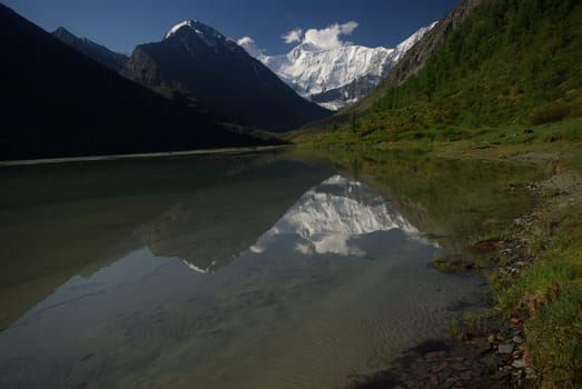 The mountain river in the mountains. Current through the gorge the river. Stones and rocky land near the river. Beautiful mountain landscape.