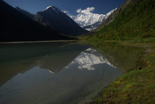 The mountain river in the mountains. Current through the gorge the river. Stones and rocky land near the river. Beautiful mountain landscape.