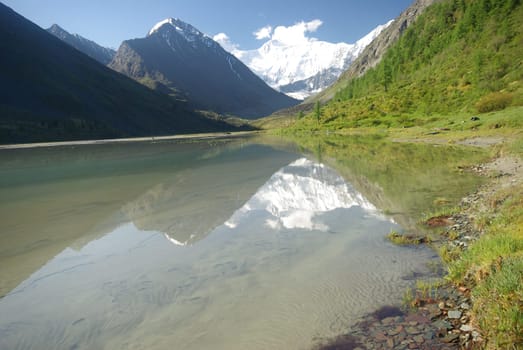 The mountain river in the mountains. Current through the gorge the river. Stones and rocky land near the river. Beautiful mountain landscape.
