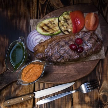 grilled beef steak with sauce and vegetables