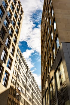 Skyscraper with square windows and sky with clouds.