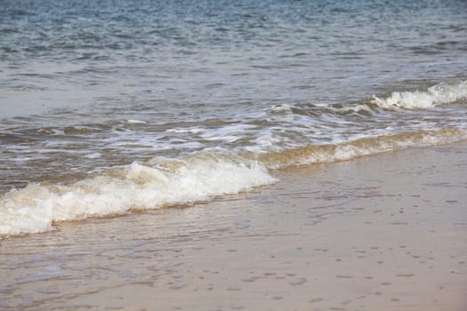 Waves with white foam crowns roll over the surface of the sea.