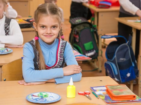 Happy first grader at a lesson in the school of technology, look in the frame
