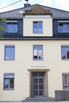 A house façade with gray windows,and year.