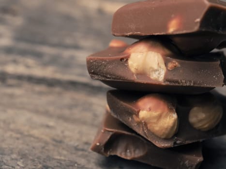Close up of stacked chocolate bars on a wooden table, vintage color toned