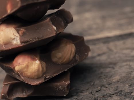 Close up of stacked chocolate bars on a wooden table, vintage color toned