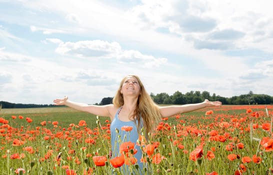 Woman cheers in the poppy field