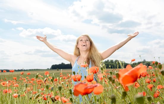 Woman cheers in the poppy field