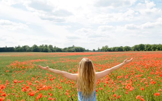 Woman cheers in the poppy field
