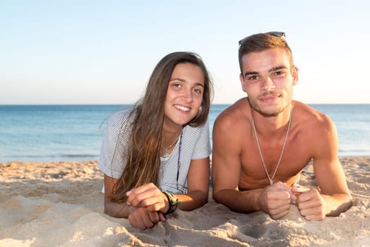Happy young couple posing in the beach