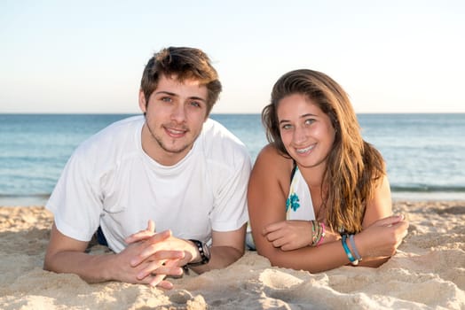 Happy young couple posing in the beach