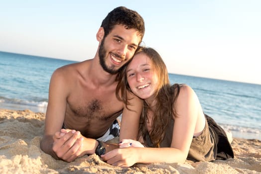 Happy young couple posing in the beach