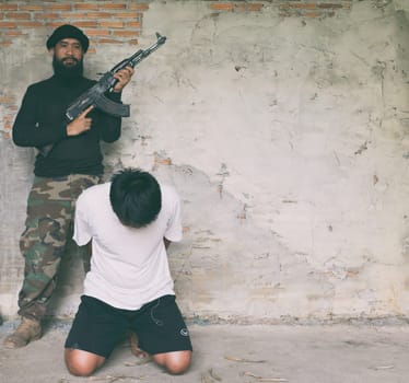 Terrorist in balaclava threatening with gun to man abducted