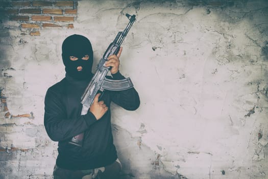terrorist in black uniform and mask with kalashnikov ak47