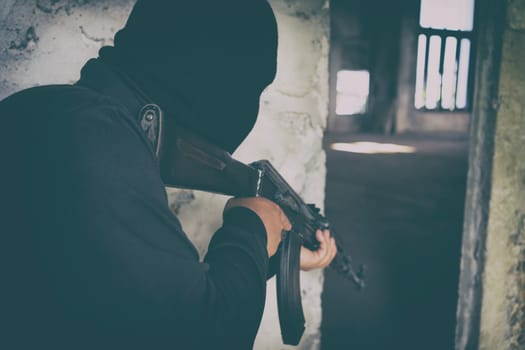 terrorist in black uniform and mask with kalashnikov ak47