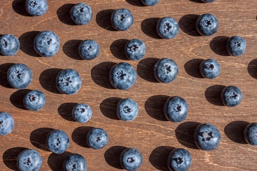 fresh big delicious blueberries wooden background bright shadows