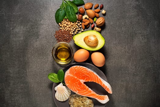 Selection of healthy food. Raw steak of salmon with fresh ingredients on gray background.