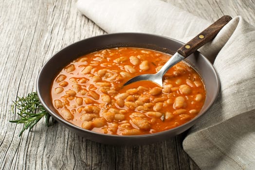 White bean stew with fresh spices on wooden table