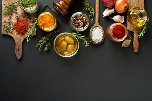 Fresh herbs and spices on a black background