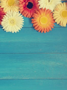 Colorful flower decoration on a blue wooden background with space for text or image