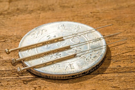 Acupuncture needle on antique Chinese coin