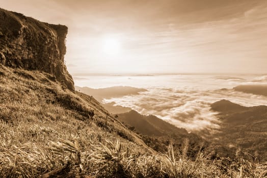 Vintage sepia color style, Beautiful landscape nature of sunrise on the clouds view from peak mountain with sun mist and bright sky at Phu Chi Fa Forest Park is a famous attractions of Chiang Rai, Thailand
