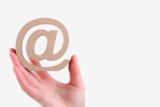 Hand holding wooden email symbol isolated on white background