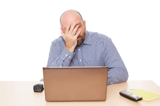 A depressed businessman at his desk against a white background