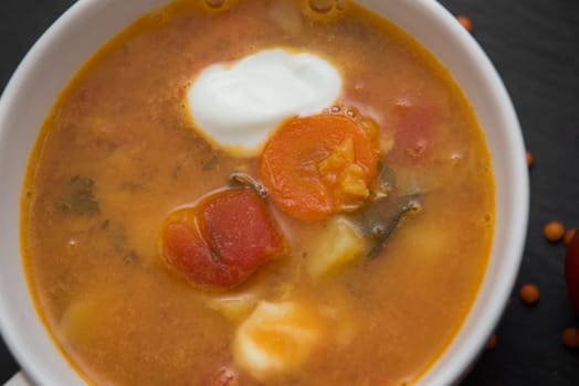 close up on soup with tomato,lentil and potato,rustical background,top view