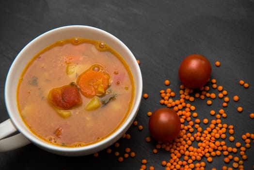 close up on soup with tomato,lentil and potato,rustical background,top view