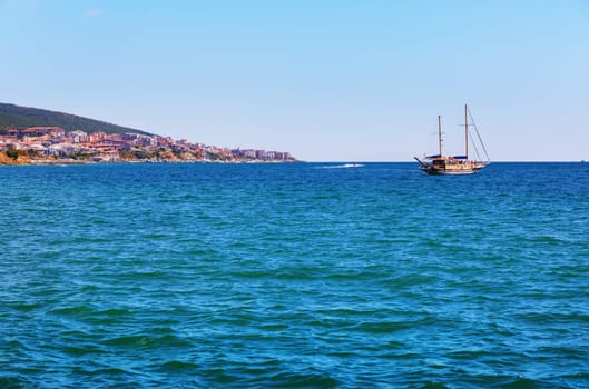Picturesque seascape. Black Sea coast. Pleasure yacht and shore on the horizon.