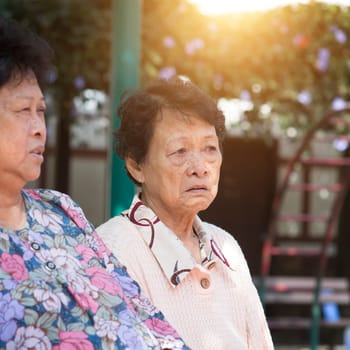 Candid shot of Asian mature women chatting at outdoor park in the morning.