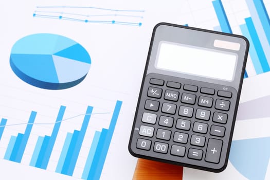 finance business calculator on chart printed documents