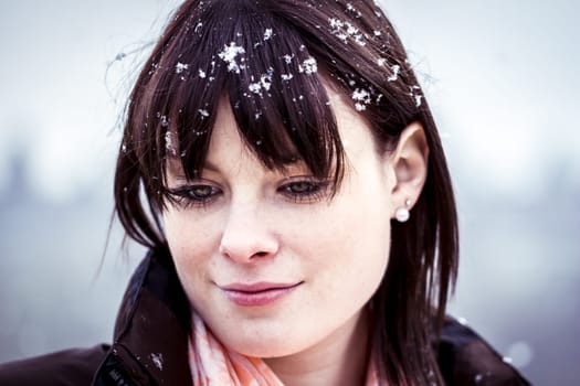 The young woman feels alone. She has snow in her hair and a lot of sorrows in her beautiful face.