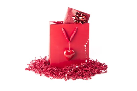 Wonderful red gift with a card inside, maybe voucher or concert tickets for Valentine's Day or Mother's Day. Isolated on white background.