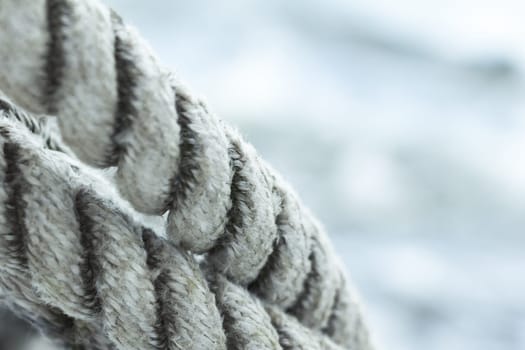 Close up with clean ropes in foreground and water copy space in background.
