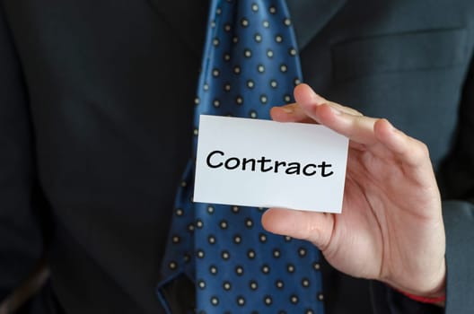 Contract text note concept over business man background.