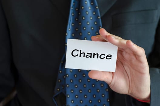 Chance text note concept over business man background.