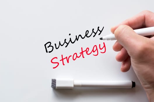 Human hand writing business strategy on whiteboard