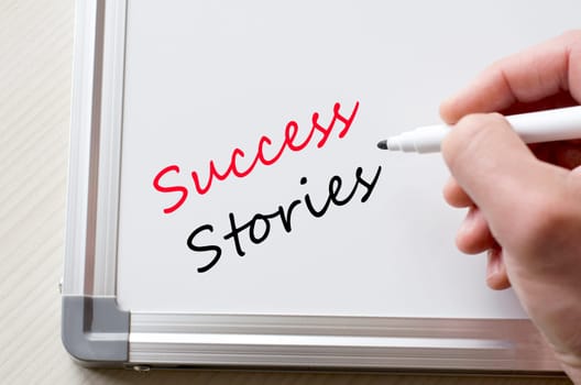 Human hand writing success stories on whiteboard