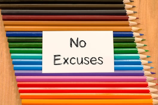 Blank white paper and colored pencil on wooden background