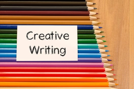 Blank white paper and colored pencil on wooden background