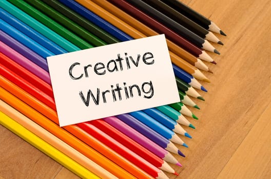 Blank white paper and colored pencil on wooden background